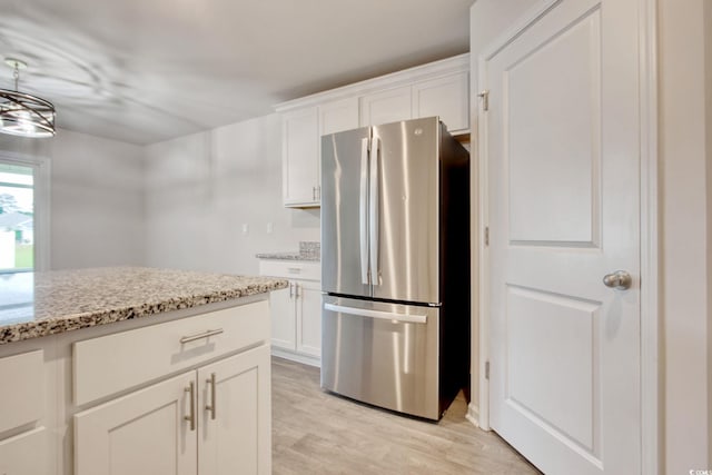 211 Seasons Trace Loop, Longs, SC 29568 - kitchen with freestanding refrigerator, light wood-style floors, light stone counters, and white cabinets
