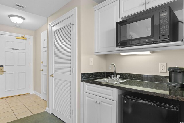 9994 Beach Club Dr Unit 1202, Myrtle Beach, SC 29572 - kitchen featuring black microwave, refrigerator, white cabinets, light tile patterned floors, and dark stone counters