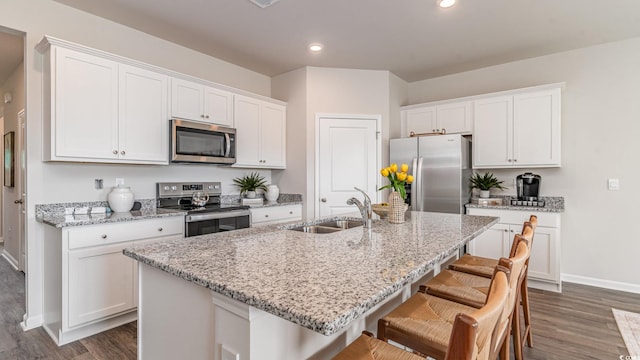 1407 Nokota Dr, Conway, SC 29526 - kitchen featuring appliances with stainless steel finishes, dark wood-type flooring, white cabinetry, a kitchen bar, and recessed lighting