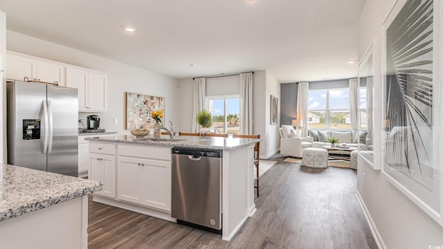 1407 Nokota Dr, Conway, SC 29526 - kitchen with appliances with stainless steel finishes, dark wood-style flooring, open floor plan, white cabinetry, and a kitchen island with sink