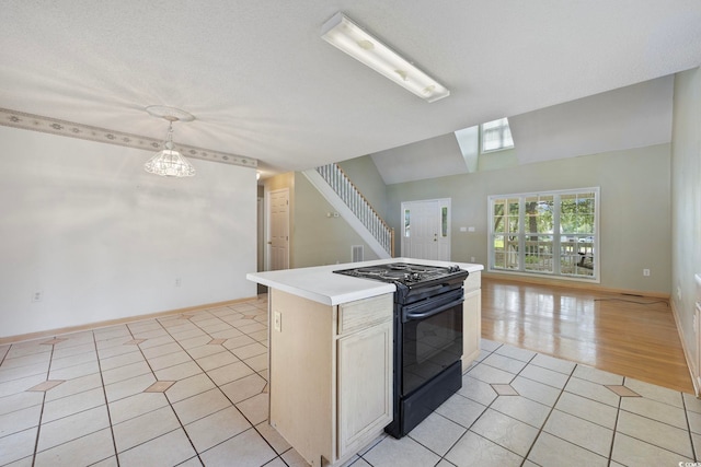 7288 Schooners Ct SW, Ocean Isle Beach, NC 28469 - kitchen featuring black range oven, light tile patterned floors, light countertops, open floor plan, and a center island