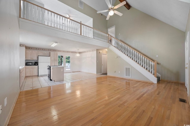 7288 Schooners Ct SW, Ocean Isle Beach, NC 28469 - unfurnished living room with high vaulted ceiling, light wood-style flooring, ceiling fan, beam ceiling, and stairs