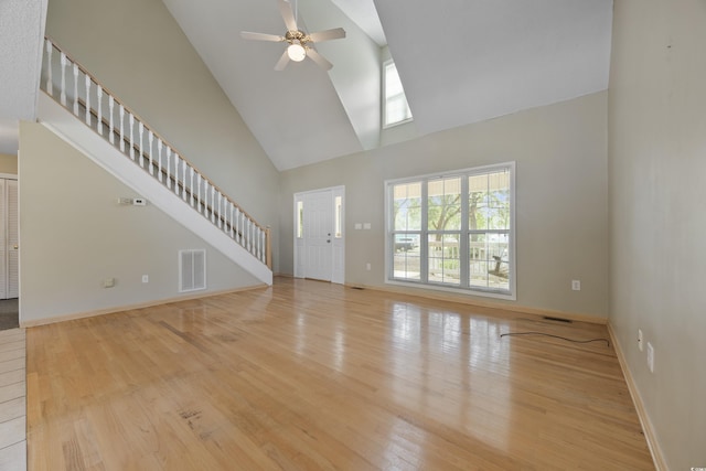 7288 Schooners Ct SW, Ocean Isle Beach, NC 28469 - unfurnished living room featuring high vaulted ceiling, light wood-style flooring, ceiling fan, and stairs