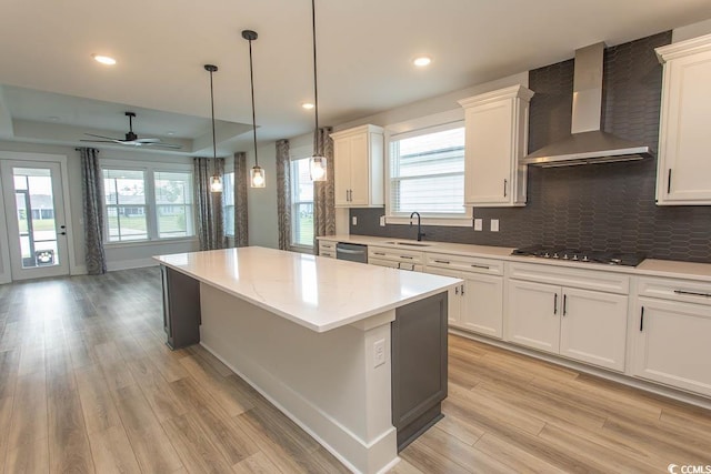 1514 Saw Palmetto St, North Myrtle Beach, SC 29582 - kitchen featuring wall chimney exhaust hood, black cooktop, dishwasher, a kitchen island, and light wood-style floors