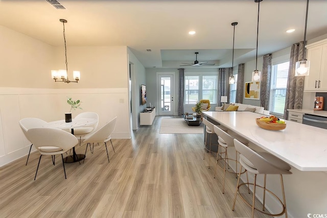 1514 Saw Palmetto St, North Myrtle Beach, SC 29582 - kitchen with white cabinets, light countertops, light wood-style floors, a kitchen island, and a kitchen bar