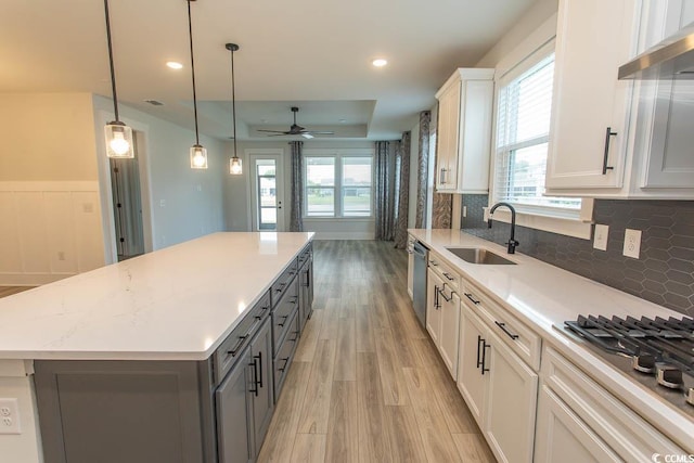 1514 Saw Palmetto St, North Myrtle Beach, SC 29582 - kitchen featuring light wood-type flooring, wall chimney range hood, a center island, gray cabinetry, and a ceiling fan