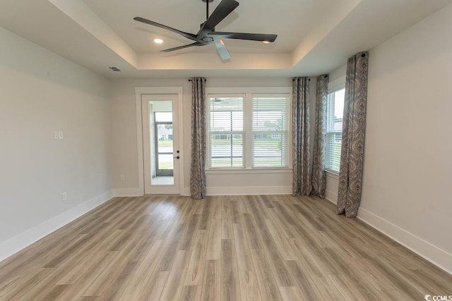 1514 Saw Palmetto St, North Myrtle Beach, SC 29582 - empty room with a tray ceiling, plenty of natural light, light wood-style flooring, and a ceiling fan