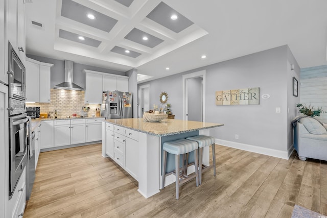 2336 Tidewatch Way N, Myrtle Beach, SC 29582 - kitchen featuring stainless steel appliances, wall chimney range hood, coffered ceiling, a kitchen island, and a breakfast bar