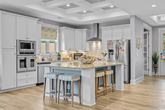2336 Tidewatch Way N, Myrtle Beach, SC 29582 - kitchen with wall chimney exhaust hood, stainless steel appliances, a kitchen island, a kitchen breakfast bar, and decorative backsplash