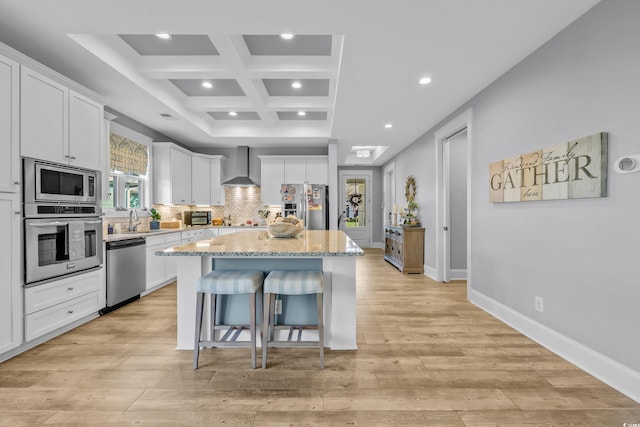 2336 Tidewatch Way N, Myrtle Beach, SC 29582 - kitchen featuring appliances with stainless steel finishes, wall chimney range hood, a breakfast bar area, coffered ceiling, and a center island