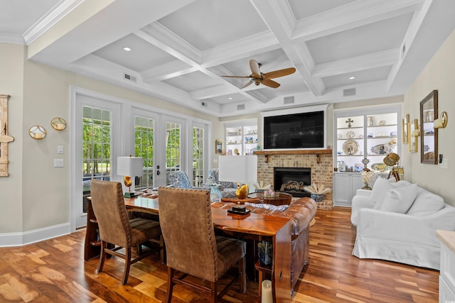 155 Preservation Cir, Pawleys Island, SC 29585 - dining space with light wood-type flooring, a brick fireplace, a ceiling fan, beam ceiling, and coffered ceiling