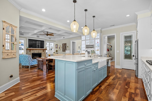 155 Preservation Cir, Pawleys Island, SC 29585 - kitchen with a fireplace, blue cabinets, light countertops, coffered ceiling, and dark wood finished floors