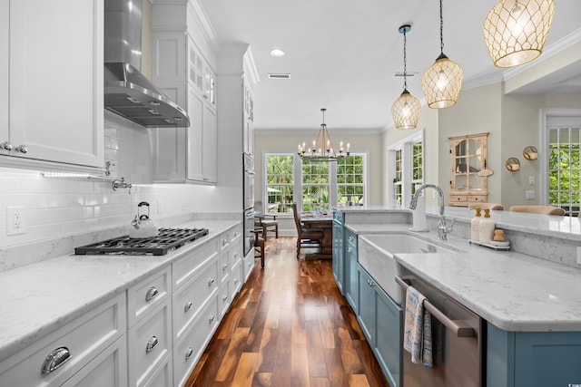 155 Preservation Cir, Pawleys Island, SC 29585 - kitchen featuring wall chimney range hood, stainless steel appliances, blue cabinets, crown molding, and white cabinetry