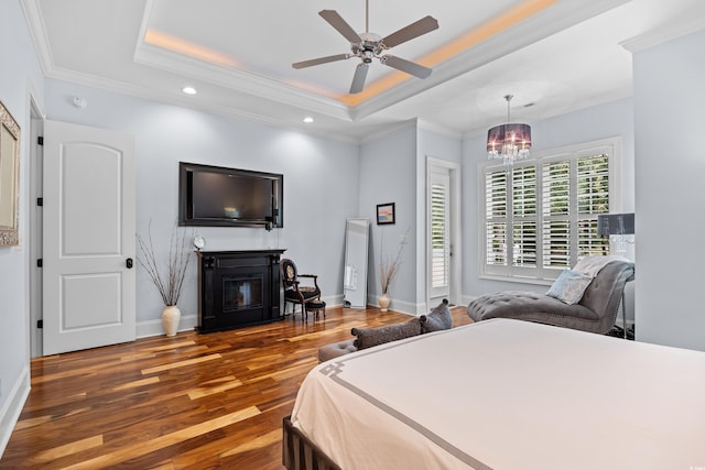 155 Preservation Cir, Pawleys Island, SC 29585 - bedroom featuring wood finished floors, crown molding, a glass covered fireplace, a chandelier, and a tray ceiling