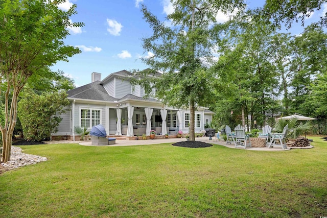 155 Preservation Cir, Pawleys Island, SC 29585 - rear view of property with a patio, an outdoor fire pit, and a lawn