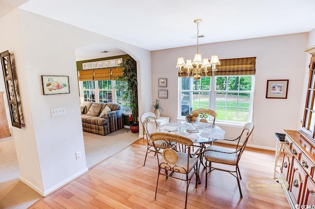 4570 Fringetree Dr, Murrells Inlet, SC 29576 - dining space with arched walkways, light wood-style floors, and a chandelier