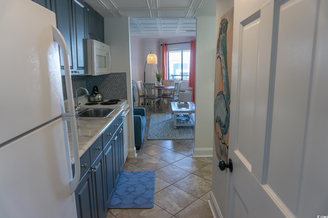 2001 S Ocean Blvd S Unit 1302, Myrtle Beach, SC 29577 - kitchen with white appliances, blue cabinetry, decorative backsplash, light countertops, and light tile patterned floors