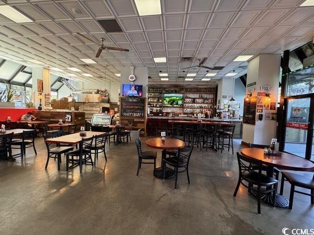 2001 S Ocean Blvd S Unit 1302, Myrtle Beach, SC 29577 - dining space featuring concrete flooring and a bar