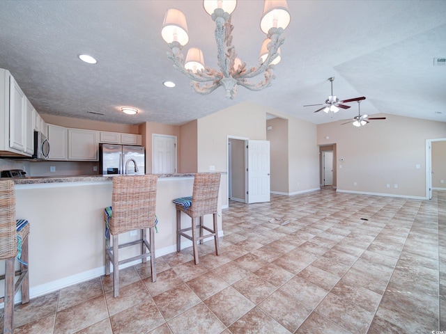 708 Shenanigan Loop, Murrells Inlet, SC 29576 - kitchen with appliances with stainless steel finishes, white cabinets, a chandelier, a ceiling fan, and a breakfast bar