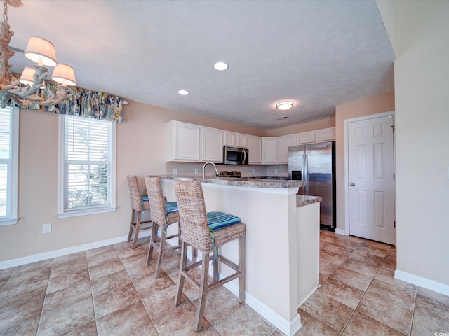 708 Shenanigan Loop, Murrells Inlet, SC 29576 - kitchen with stainless steel appliances, white cabinetry, a peninsula, a textured ceiling, and recessed lighting