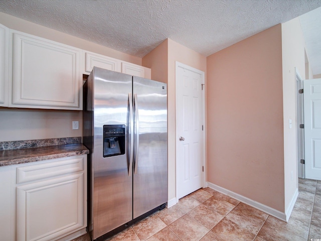 708 Shenanigan Loop, Murrells Inlet, SC 29576 - kitchen with stainless steel fridge, white cabinetry, and a textured ceiling