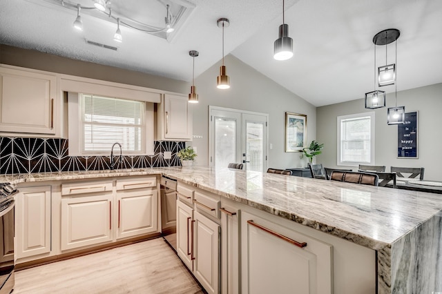 10056 Kings Rd, Myrtle Beach, SC 29572 - kitchen featuring stainless steel dishwasher, backsplash, light wood-type flooring, vaulted ceiling, and light stone counters