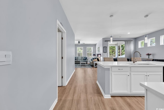 520 Cattle Drive Cir, Myrtle Beach, SC 29588 - kitchen with light wood finished floors, light countertops, white cabinetry, open floor plan, and pendant lighting