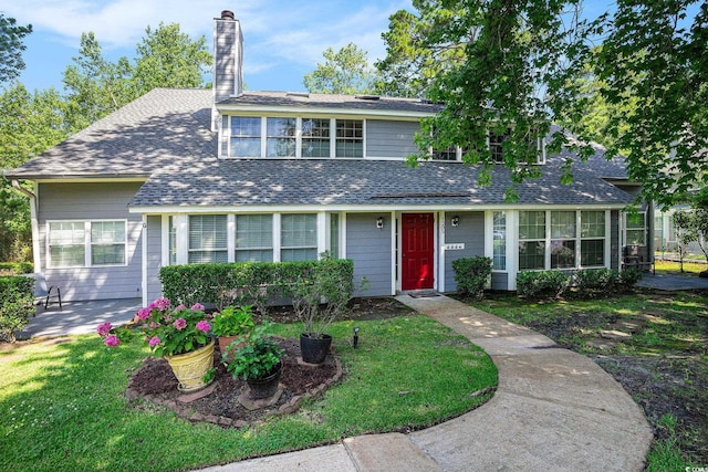 1205 Erin Way Unit 5C, Myrtle Beach, SC 29577 - view of front facade featuring a shingled roof, a chimney, a front lawn, and a patio area
