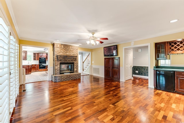 469 White Heron Ct SW, Sunset Beach, NC 28468 - unfurnished living room featuring wood finished floors, a bar, stairs, ceiling fan, and crown molding