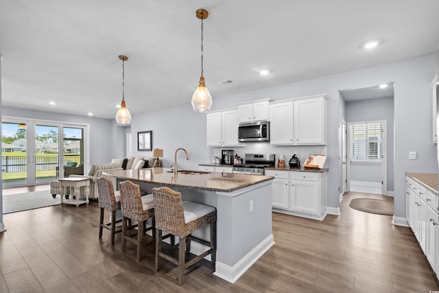 215 Kendrick St, Little River, SC 29566 - kitchen featuring appliances with stainless steel finishes, a breakfast bar, dark wood-type flooring, stone counters, and recessed lighting