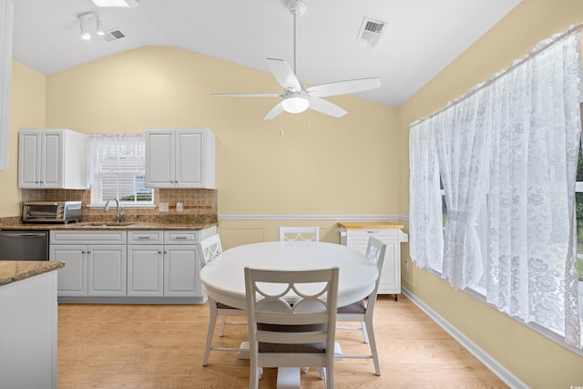4554 Fringetree Dr, Murrells Inlet, SC 29576 - dining space with vaulted ceiling, a ceiling fan, light wood-style flooring, and wainscoting