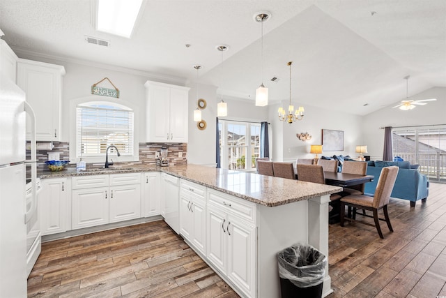 4846 Carnation Cir Unit 301, Myrtle Beach, SC 29577 - kitchen featuring light wood-style floors, a peninsula, healthy amount of natural light, open floor plan, and vaulted ceiling