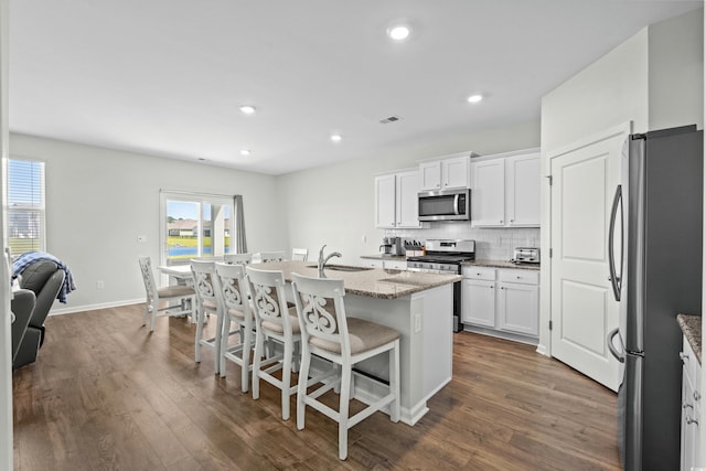2106 Ainsley Dr, Little River, SC 29566 - kitchen featuring stainless steel appliances, dark wood-style flooring, decorative backsplash, light stone countertops, and recessed lighting