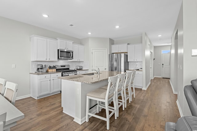 2106 Ainsley Dr, Little River, SC 29566 - kitchen featuring appliances with stainless steel finishes, decorative backsplash, wood finished floors, white cabinetry, and recessed lighting