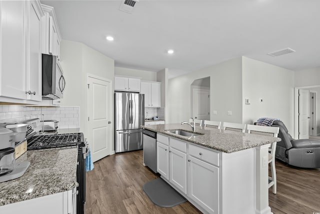 2106 Ainsley Dr, Little River, SC 29566 - kitchen featuring stainless steel appliances, a breakfast bar area, white cabinetry, dark wood-type flooring, and open floor plan