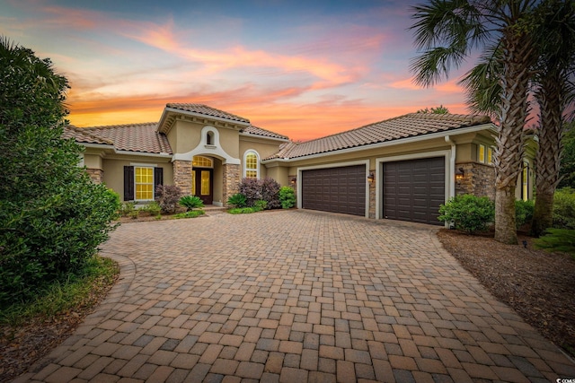 7961 San Marcello Dr, Myrtle Beach, SC 29579 - mediterranean / spanish house featuring stone siding, stucco siding, an attached garage, and decorative driveway