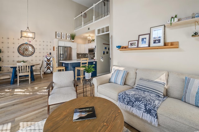 1984 Green Fern Ln Unit 1984, Myrtle Beach, SC 29579 - living room featuring light wood-style flooring, a towering ceiling, and a chandelier
