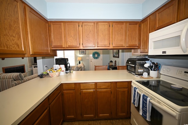 950 Tiffany Ln, North Myrtle Beach, SC 29582 - kitchen with white appliances, light countertops, brown cabinets, and a peninsula