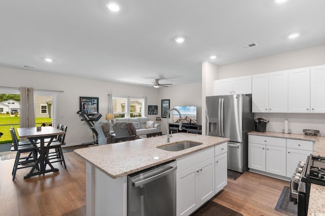 1029 Saltgrass Way, Myrtle Beach, SC 29588 - kitchen featuring appliances with stainless steel finishes, a ceiling fan, white cabinets, wood finished floors, and recessed lighting