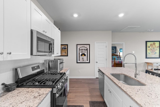 1029 Saltgrass Way, Myrtle Beach, SC 29588 - kitchen featuring appliances with stainless steel finishes, dark wood-type flooring, white cabinets, decorative backsplash, and recessed lighting