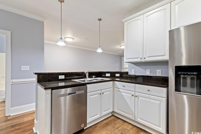 118 Birch N Coppice Dr Unit 2, Surfside Beach, SC 29575 - kitchen with appliances with stainless steel finishes, ornamental molding, a peninsula, light wood finished floors, and decorative light fixtures