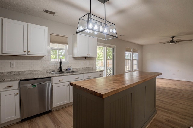 1897 Mossberg Dr, Sumter, SC 29150 - kitchen with dishwasher, butcher block counters, a center island, plenty of natural light, and a textured ceiling