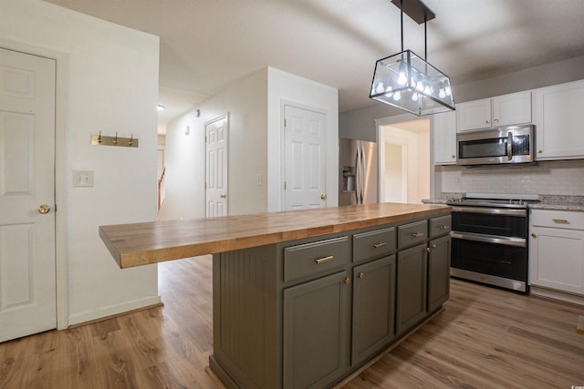 1897 Mossberg Dr, Sumter, SC 29150 - kitchen featuring stainless steel appliances, wooden counters, light wood-style floors, and white cabinetry