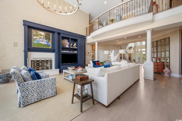 100 Ocean Park Loop, Georgetown, SC 29440 - living room featuring decorative columns, a towering ceiling, light wood finished floors, and a chandelier