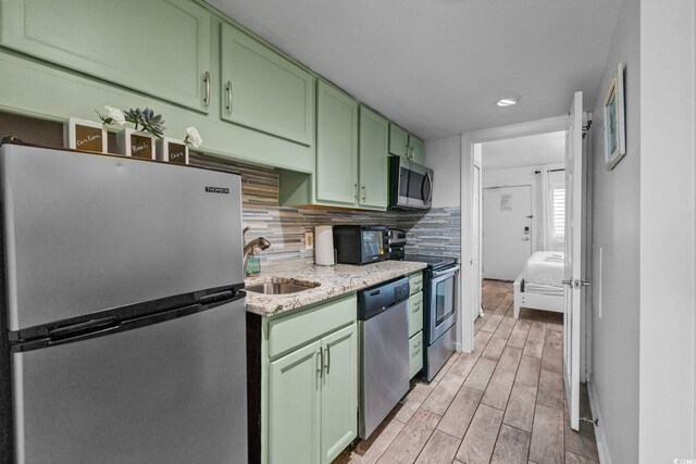 2001 S Ocean Blvd Unit 1405, Myrtle Beach, SC 29577 - kitchen featuring stainless steel appliances, green cabinetry, light wood-style floors, recessed lighting, and backsplash