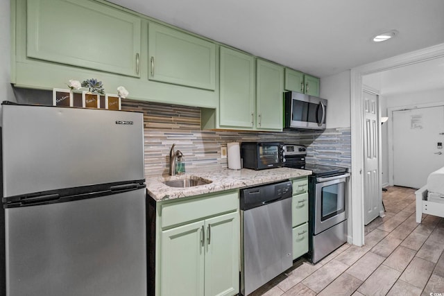 2001 S Ocean Blvd Unit 1405, Myrtle Beach, SC 29577 - kitchen featuring stainless steel appliances, green cabinets, decorative backsplash, light stone countertops, and light wood-style flooring