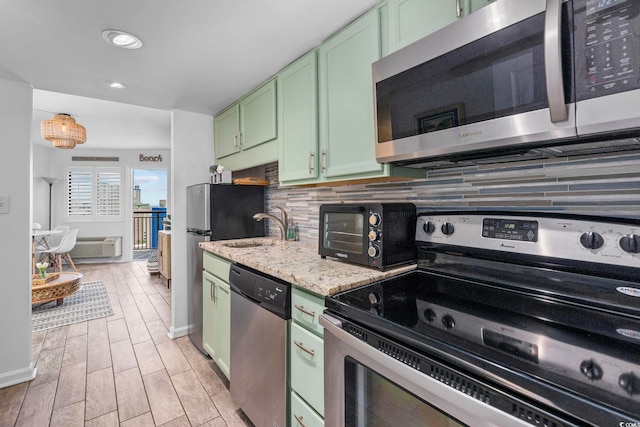 2001 S Ocean Blvd Unit 1405, Myrtle Beach, SC 29577 - kitchen with green cabinets, appliances with stainless steel finishes, backsplash, light stone countertops, and light wood-style flooring
