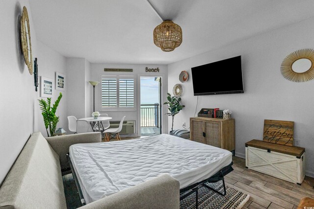 2001 S Ocean Blvd Unit 1405, Myrtle Beach, SC 29577 - bedroom featuring access to exterior, wood finished floors, and a wall mounted air conditioner