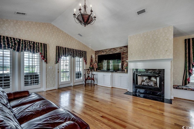 1473 Basin Trl, Murrells Inlet, SC 29576 - living area featuring light wood-style floors, vaulted ceiling, a chandelier, and a fireplace with flush hearth