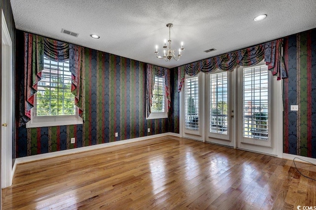 1473 Basin Trl, Murrells Inlet, SC 29576 - spare room featuring wallpapered walls, a chandelier, a textured ceiling, wood finished floors, and recessed lighting